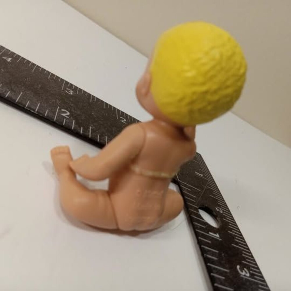Small plastic baby doll with yellow hair